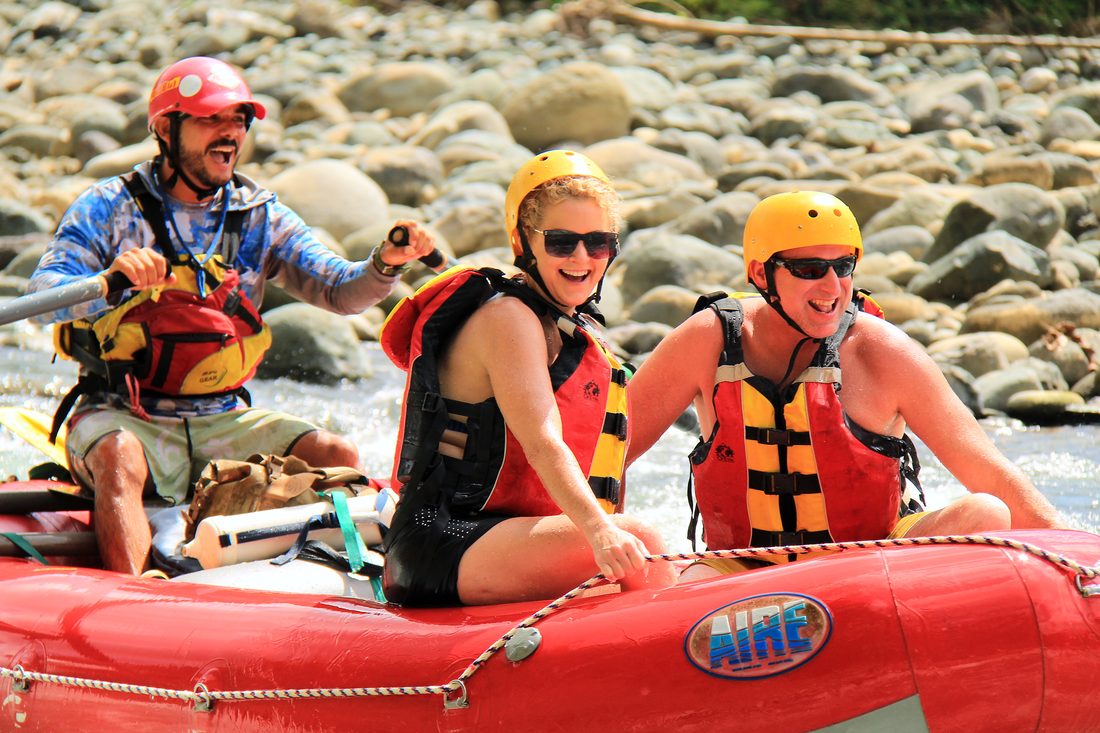 Happy guests sitting back in the safari raft