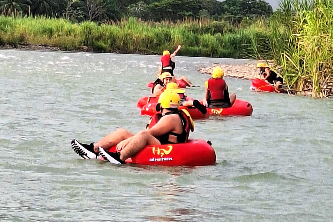 Guests in their tubes floating down the Naranjo, with the jungle on the bank
