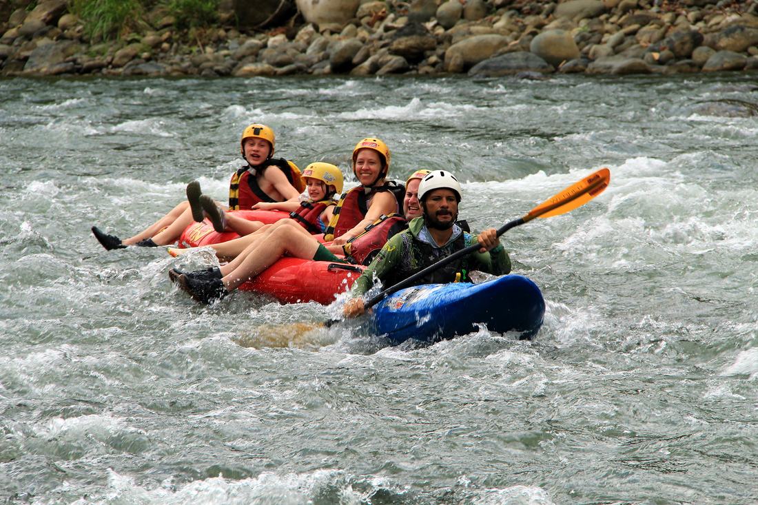 Guests tubing a rapid on the Savegre with their guide
